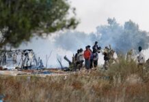 Tunisie : 10 000 migrants rapatriés en 2025, Tunis affirme son refus de devenir une zone de transit Migrants gather near burnt tents, as Tunisian authorities have dismantled makeshift camps housing sub-Saharan African migrants, in Amra, Sfax, Tunisia April 24, 2025. REUTERS/Zoubeir Souissi
